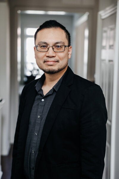 Portrait of Alexander Yong wearing gray button-up and black jacket